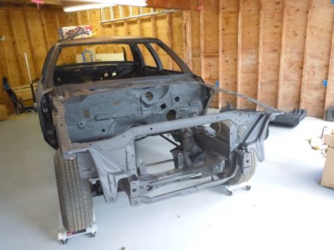 2001 Ford Crown Victoria - Stripped 2001 Ford Crown Victoria body shell undergoing restoration in a garage.