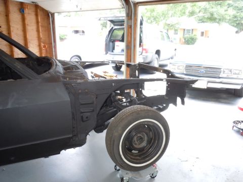 2001 Ford Crown Victoria - A car body is being worked on in a garage, with other vehicles visible outside.