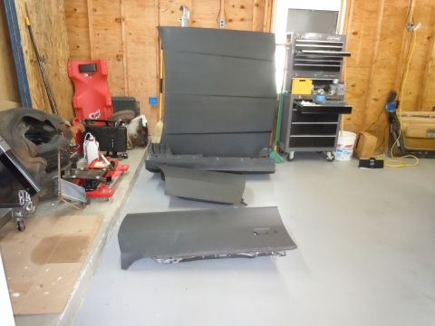 2001 Ford Crown Victoria - Various car parts are laid out in a garage, including a door and a hood.