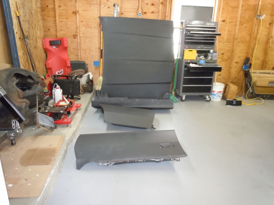 Car door and hood in a garage with tools