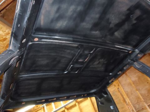 2001 Ford Crown Victoria - The bare metal interior roof structure of a vehicle is visible, showing the framework and bracing.