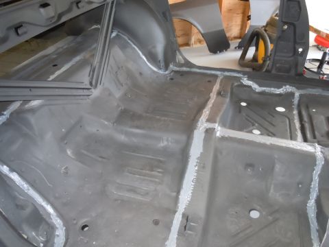 2001 Ford Crown Victoria - The bare metal floor pan of a car interior, prepped for further work.