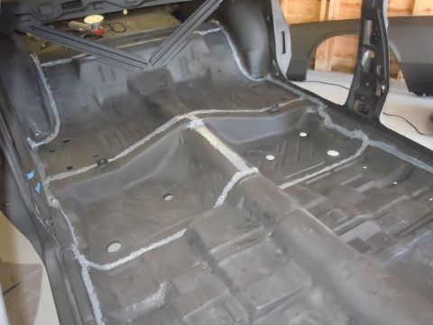 2001 Ford Crown Victoria - The interior floor pan of a vehicle has been stripped and welded, preparing it for further restoration work.