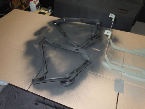 2001 Ford Crown Victoria - Car hood hinges are laid out on cardboard for painting, with a car door visible in the background.