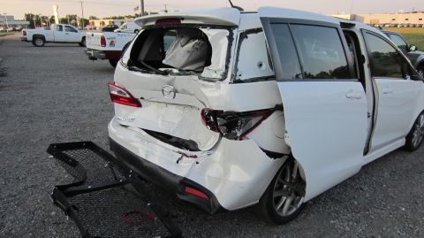 2012 Mazda Mazda 5 - This minivan has sustained significant damage to its rear end, with shattered glass and crumpled body panels.