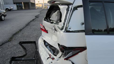 2012 Mazda Mazda 5 - The rear of a white Mazda 5 shows extensive damage, including a broken rear window and crumpled bodywork.