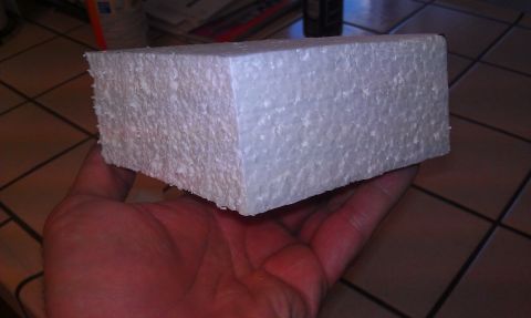 1989 Ford Bronco - A hand holds a rectangular block of white styrofoam.