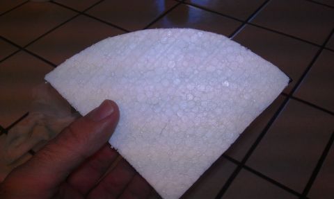 1989 Ford Bronco - A hand holds a piece of styrofoam, which is shaped like a segment of a circle.
