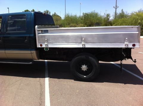 1999 Ford F-250 - Side view of a 1999 Ford F-250 pickup truck, a teal and tan two-tone paint scheme and a silver flatbed.