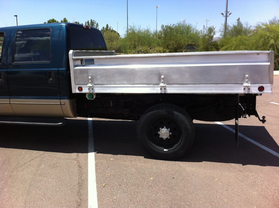 1999 Ford F-250 pickup truck with a teal cab and tan lower body, fitted with a silver flatbed