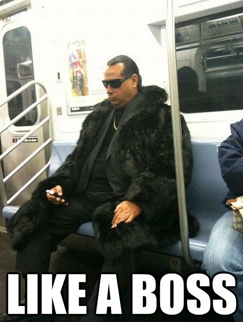 1999 Ford F-250 - A man in a fur coat sits on a subway train, looking down and holding a cigarette.