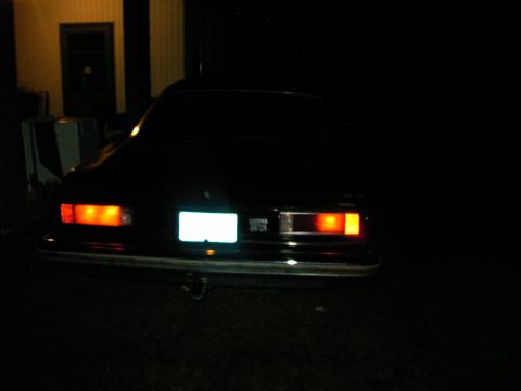 1975 Chevrolet Chevelle - Rear view of a dark-colored sedan at night, showing its taillights and license plate area.