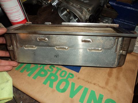 2004 Mercury Grand Marquis - Close-up of an aftermarket oil pan with visible welds, resting on a cardboard box.