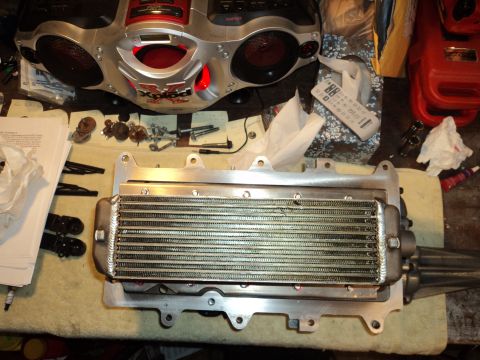 2004 Mercury Grand Marquis - A supercharger intercooler assembly is laid out on a table with tools and a boombox in the background.