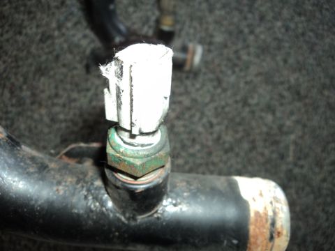 2004 Mercury Grand Marquis - Close-up of a sensor mounted on a pipe, a white electrical connector.