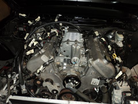 2004 Mercury Grand Marquis - Close-up of a V8 engine with a supercharger installed, showing extensive wiring and engine components.