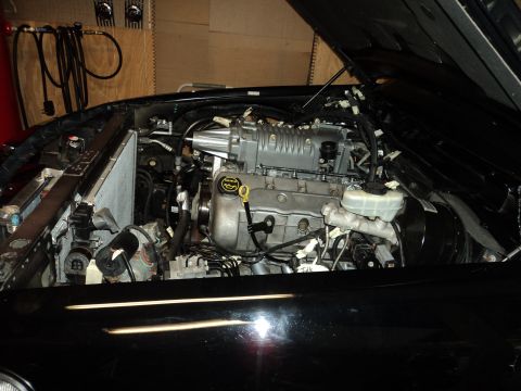 2004 Mercury Grand Marquis - Engine bay view showing a supercharger fitted to the engine. The hood is open, revealing the engine components.