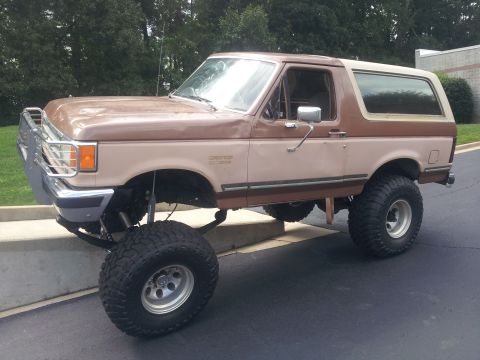 1988 Ford Bronco - This lifted Ford Bronco features a two-tone brown paint scheme and sits high on large off-road tires.