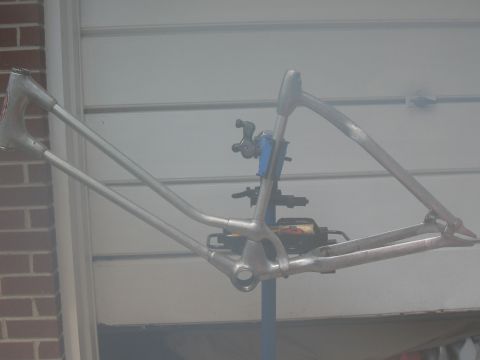 1994 Ford Bronco - A bare bicycle frame is mounted on a stand in front of a garage door.
