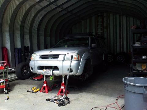 2003 Nissan Frontier - Front view of a 2003 Nissan Frontier truck being worked on in a garage.