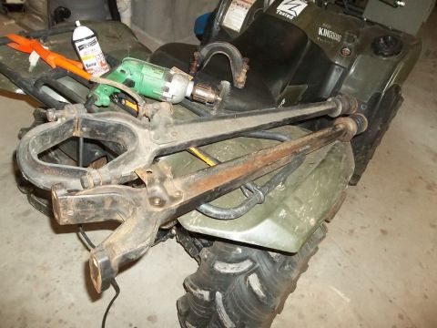 1995 Ford Bronco - A green ATV is loaded with suspension parts, a drill, and a can of spray paint.