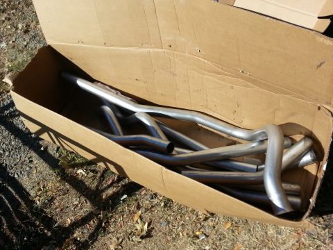 1978 Ford Bronco - A box of exhaust pipes sits on the ground, ready for installation or storage.