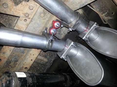 1978 Ford Bronco - Close-up view of a dual exhaust system installation, new mufflers and red rubber hangers.