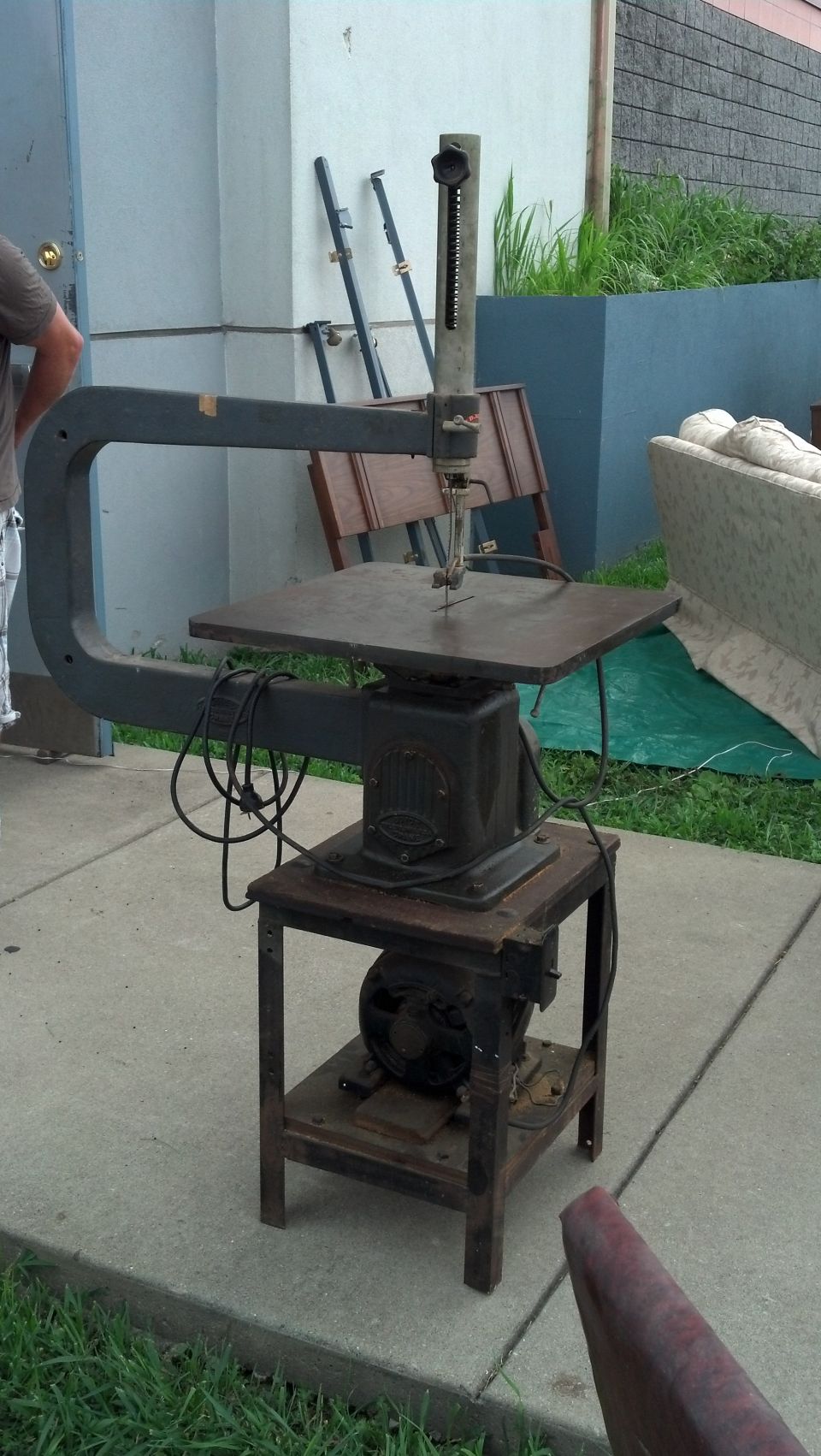 Old scroll saw with a metal stand and motor