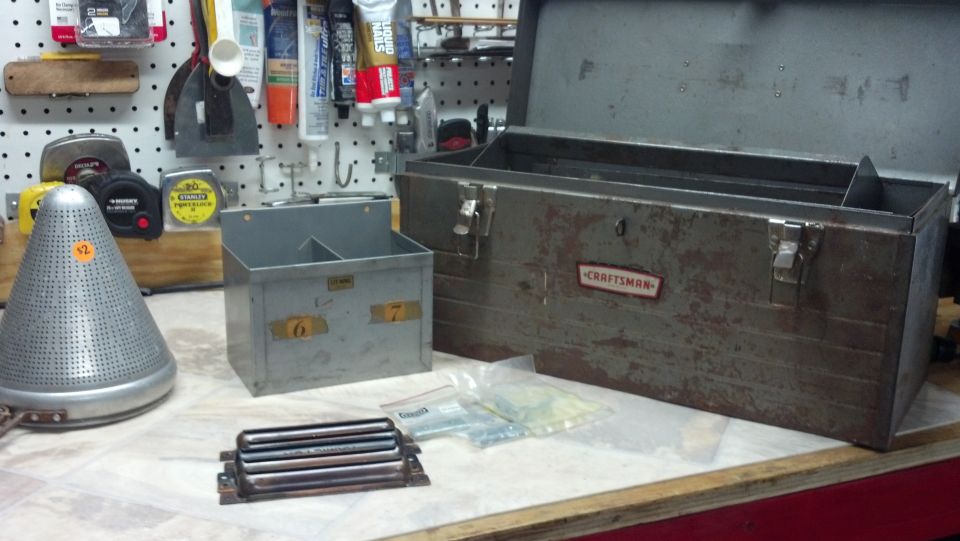 Old metal toolbox with 'Craftsman' label, a perforated metal cone, and a small organizer bin with numbers 6 and 7 on it