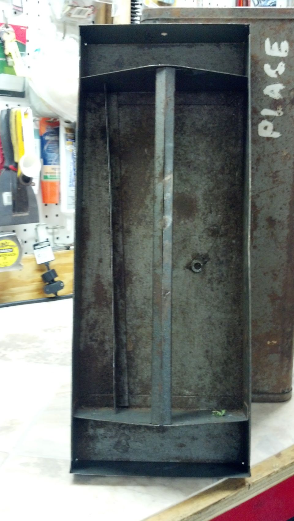 Rusty metal container with internal dividers, viewed from above