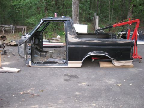 1990 Ford Bronco - The body of a Ford Bronco is shown disassembled, with the doors removed and interior exposed.