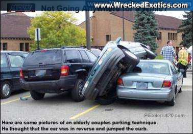 1998 Mercury Sable - Two cars are crashed together in a parking lot, with one vehicle on top of the other.