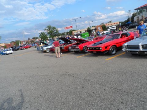 1971 Ford Ranchero - Several classic cars are on display at an outdoor event under a cloudy sky.
