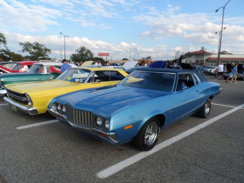 1971 Ford Ranchero - A blue 1972 Ford Gran Torino is parked in a lot with other vehicles under a cloudy sky.