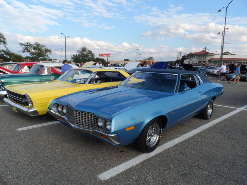 Blue 1972 Ford Gran Torino parked at a car show, with other classic cars in the background