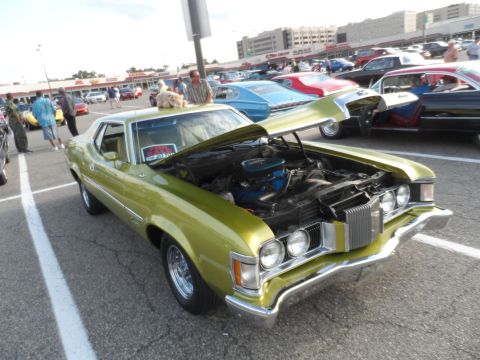 1971 Ford Ranchero - A lime green 1970 Mercury Cougar XR7 coupe is displayed with its hood open at an outdoor car show.