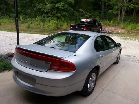 2007 Dodge Durango - A silver sedan is parked on a concrete driveway with a black pickup truck behind it.