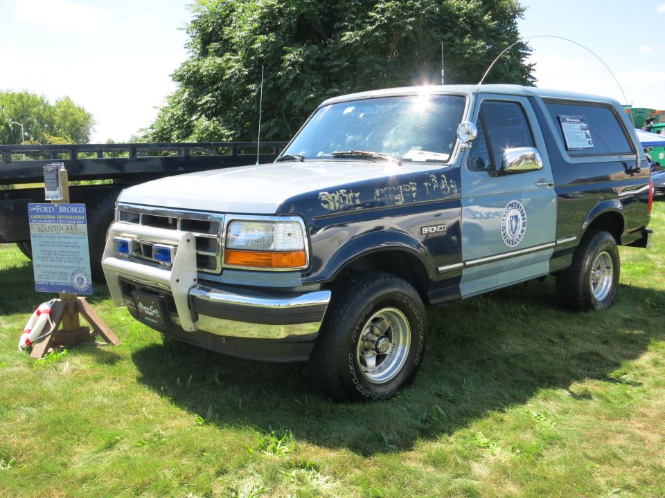 Two-tone blue and silver Ford Bronco with a push bar and police markings