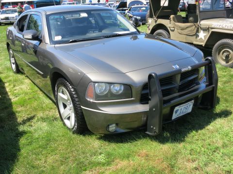 2001 Ford Crown Victoria - Gray Dodge Charger police car with push bar is parked on grass, with other vehicles visible.