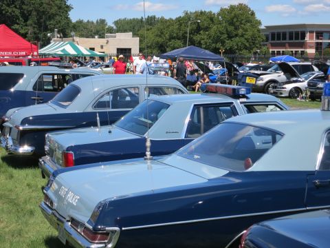 2001 Ford Crown Victoria - A lineup of classic police cruisers, including a vehicle marked "State Police," at an outdoor event.