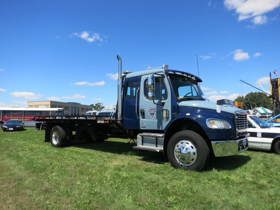 Blue and gray tow truck with chrome stacks and flatbed