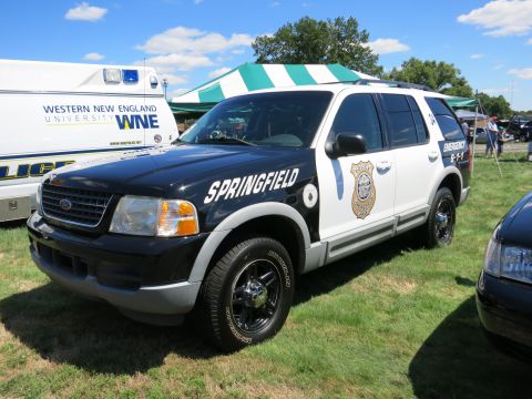2001 Ford Crown Victoria - A black and white police SUV is parked on grass next to an ambulance and another vehicle.
