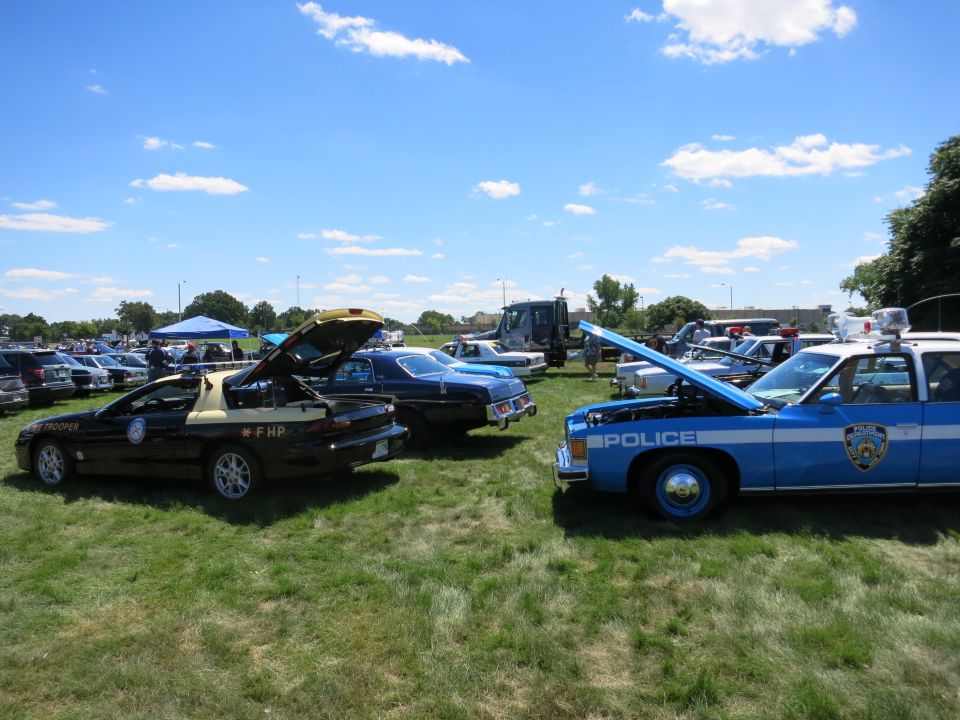 Blue and white police car with hood open, "POLICE" text visible