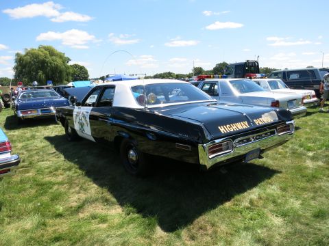 2001 Ford Crown Victoria - A classic black and white patrol car with "HIGHWAY PATROL" text on the trunk is parked on grass with other vehicles.