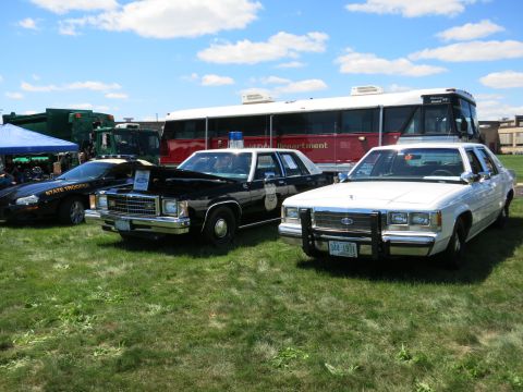 2001 Ford Crown Victoria - White police car with push bumper and license plate 344 1971 parked on grass.