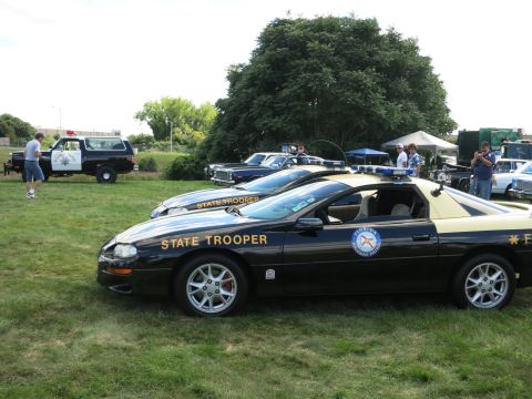 2001 Ford Crown Victoria - A Florida Highway Patrol car, marked "STATE TROOPER", is parked on a grassy field alongside other vehicles.