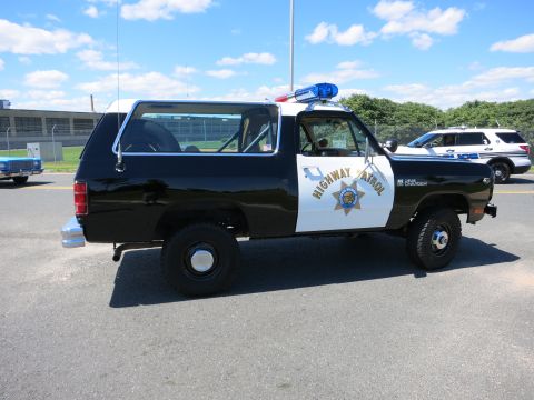 2001 Ford Crown Victoria - A black and white SUV marked "HIGHWAY PATROL" is parked on asphalt, with another police vehicle visible in the background.