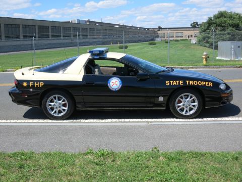 2001 Ford Crown Victoria - Florida Highway Patrol car, marked "STATE TROOPER" and "FHP", with a light bar on the roof.