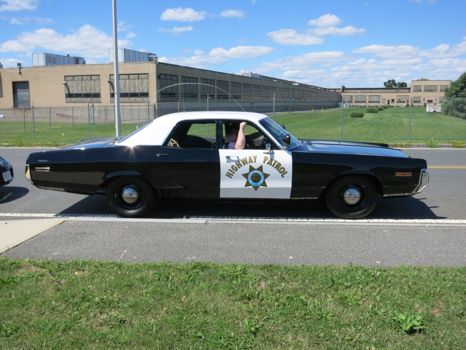 Black and white highway patrol car with "HIGHWAY PATROL" text and a star emblem on the door
