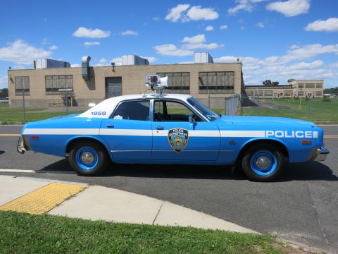 2001 Ford Crown Victoria - This side view shows a blue and white police car, identified by the '1959' marking and 'POLICE' text on the door.